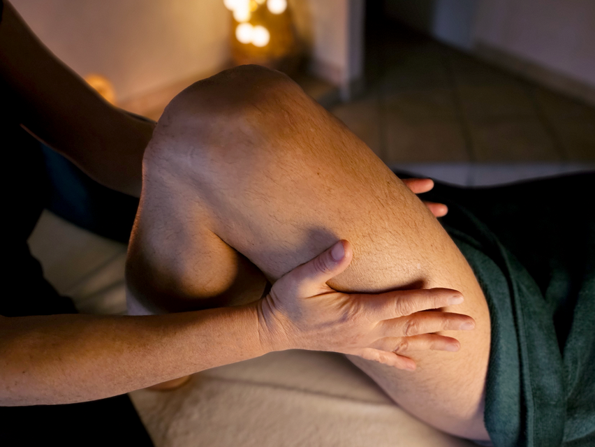 Photographie d'un plan rapproché de Nathalie massant une cuisse.