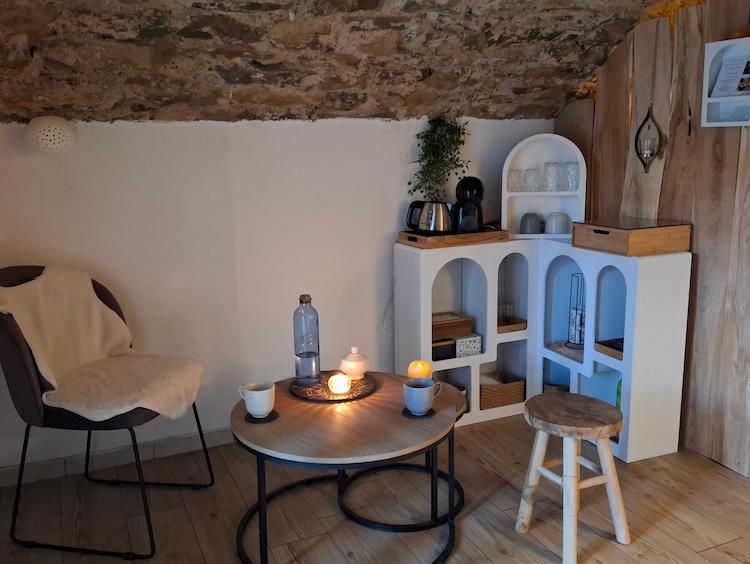 Photographie de l'entrée du salon avec une table basse et une étagère.