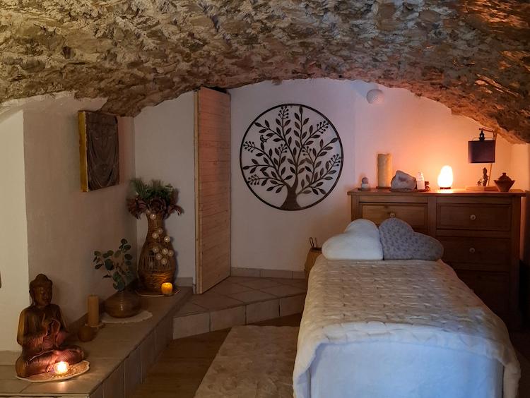 Photographie du salon avec le lit au centre et différentes décorations. La lumière est tamisée.