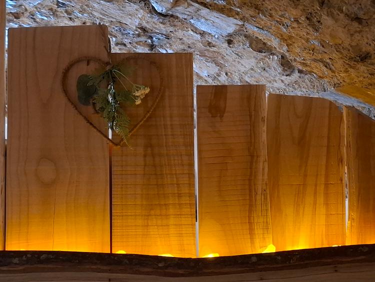 Photographie de détail du panneau en bois avec un coeur en bois attaché.