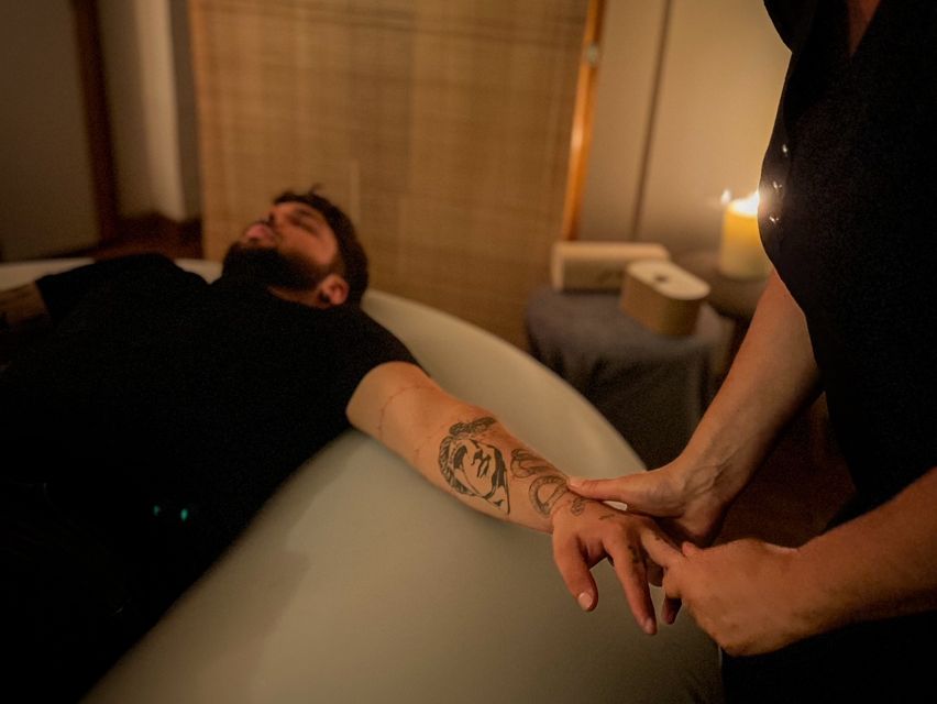 Photographie d'un homme allongé sur un coussin de massage en train de se faire masser les doigts par Nathalie.