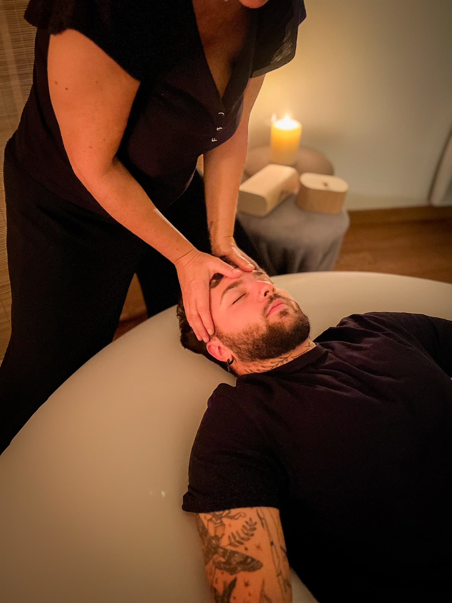 Une séance de massage assis en extérieur, Nathalie masse la nuque de la personne, assise sur une chaise de massage ergonomique